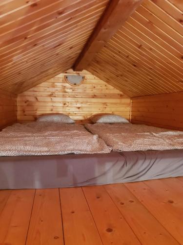 - une chambre avec 2 lits dans un grenier en bois dans l'établissement Holiday Village Tatralandia Bungalov 3-2-2 chatka 431 s 1 spálňou 1 obývačkou a 1 izbou v podkrovi, à Liptovský Mikuláš