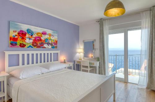 a bedroom with a white bed and a large window at Summer House Bougainvillea by Dubrovnik Colors in Blato
