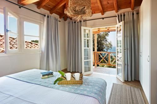 a bedroom with a bed and a large window at Skiathos Villa Ira in Koukounaries