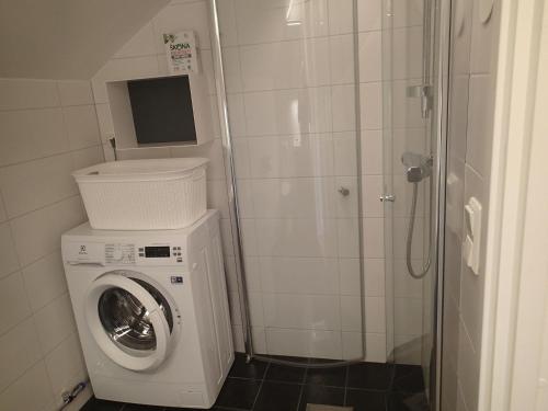 a small bathroom with a washing machine and a shower at Bubblans Apartments in Åre