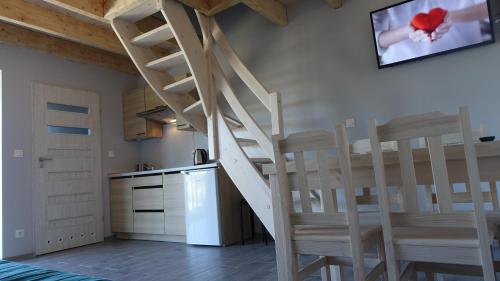 escalera en una cocina con sillas y nevera en Ośrodek Wypoczynkowy Domki Nadika en Bobolin