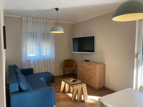 un salon avec un canapé bleu et une télévision dans l'établissement M Plus Residence, à Pinezići
