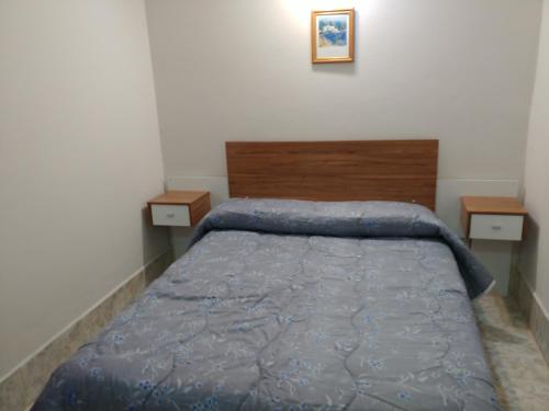 a bedroom with a bed with a blue comforter at Ankara 1 in Las Grutas