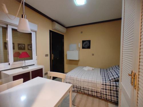 Habitación con cama, mesa y cocina. en Estudio Lorenzo Acogedor en Madrid