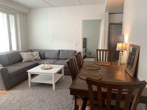 a living room with a couch and a table at Modern one bedroom apartment nearby Airport in Vantaa
