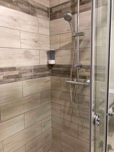 a bathroom with a shower with a glass door at PROGÎTES "Le Cottage" in Quiévrain