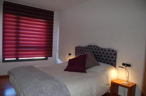 - une chambre avec un lit et une fenêtre avec des stores rouges dans l'établissement APARTAMENT TUCAMP nº6275, à Encamp