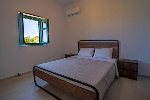 a bedroom with a bed and a window at Sugar Stone House in Pyrgos Dirou