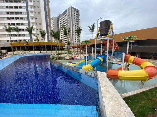a swimming pool with a water slide in a resort at Apartamento dentro de resort próximo do Thermas dos Laranjais in Olímpia
