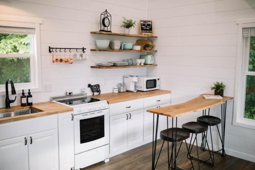 eine Küche mit weißen Schränken und einer hölzernen Arbeitsplatte in der Unterkunft New Tiny Home on 250 Acre Dairy Farm Near Ark in Dry Ridge