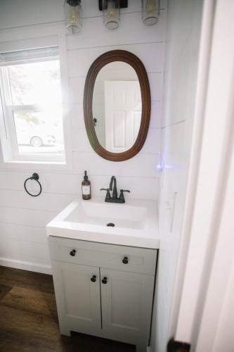 a bathroom with a white sink and a mirror at Cozy Cottage on 250 Acre Dairy Farm Near Ark in Dry Ridge