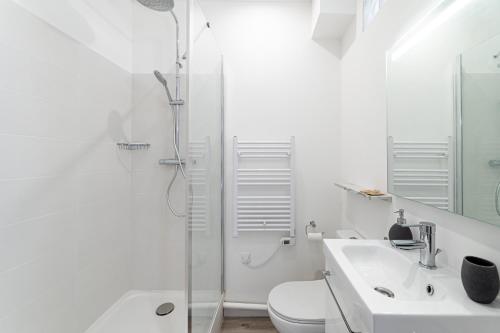 La salle de bains blanche est pourvue d'une douche et d'un lavabo. dans l'établissement Marseille: Superbe vue sur Notre-Dame de la Garde, à Marseille
