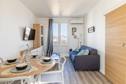 un salon avec une table et un canapé bleu dans l'établissement Marseille: Superbe vue sur Notre-Dame de la Garde, à Marseille