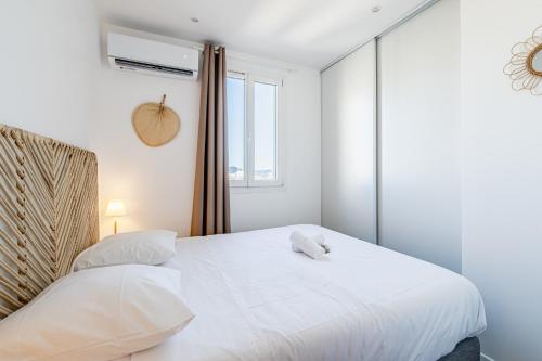 - une chambre avec un grand lit blanc et une fenêtre dans l'établissement Marseille: Superbe vue sur Notre-Dame de la Garde, à Marseille