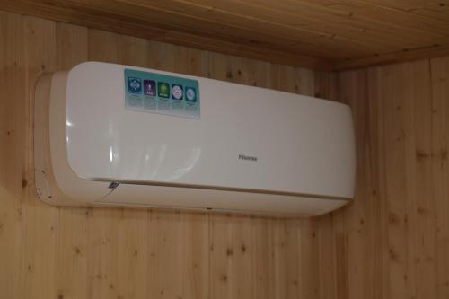 a white appliance hanging on a wooden wall at Hayi Tun Guest House in Goris
