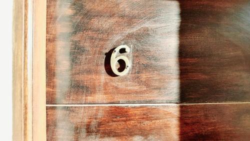 a wooden door with the number six on it at Duna 6 in Mar de las Pampas