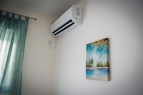une pièce avec un climatiseur et un tableau au mur dans l'établissement Apartment Sunce, à Trebinje