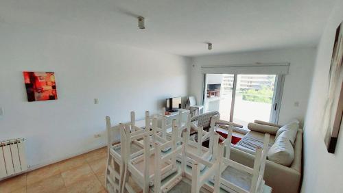 a living room with white chairs and a couch at Duna 6 in Mar de las Pampas