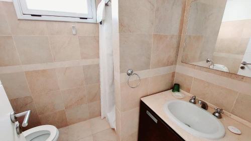 a bathroom with a sink and a toilet and a mirror at Duna 6 in Mar de las Pampas
