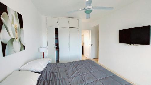 a bedroom with a bed and a tv on a wall at Duna 6 in Mar de las Pampas