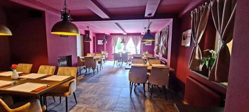 a restaurant with wooden tables and chairs and purple walls at Horská chata Plzeňka Pernink in Pernink