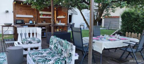 a patio with a table and chairs and a bar at Le petit coin au bord du lac in Doussard