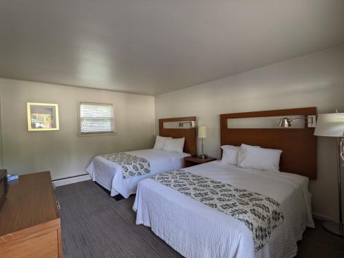 a hotel room with two beds and a table at Perry's Motel and Cottages in North Conway