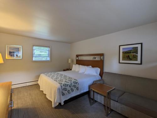 pokój hotelowy z łóżkiem i kanapą w obiekcie Perry's Motel and Cottages w mieście North Conway