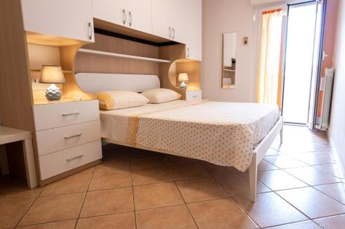 um quarto com uma cama com uma cabeceira em madeira e uma mesa em Casa di Franco em Alba Adriatica