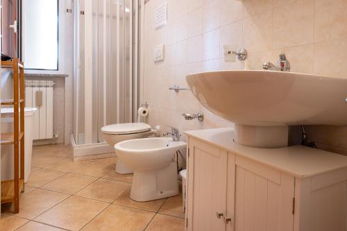 a white bathroom with a sink and a toilet at Casa di Franco in Alba Adriatica