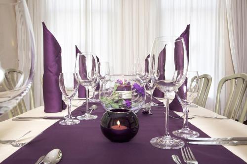 a table with wine glasses and a candle on it at Kleefelder Hof in Hannover
