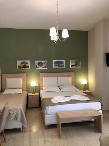 a bedroom with two beds and a green wall at Spyridonou House in Parga