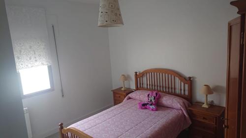 a bedroom with a bed with a purple bedspread and a pink stuffed animal at Foz Playas in Foz