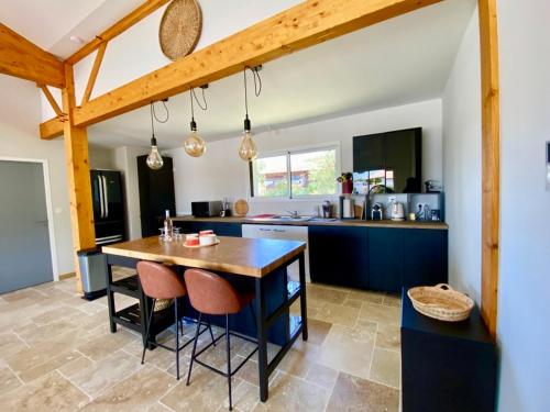 a kitchen with a table and chairs in a room at Magnifique villa avec piscine in Escource