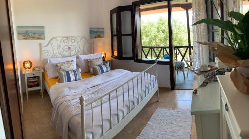 a bedroom with a bed and a large window at Mikiverna Seas the Day ! in Kalivia Poligirou