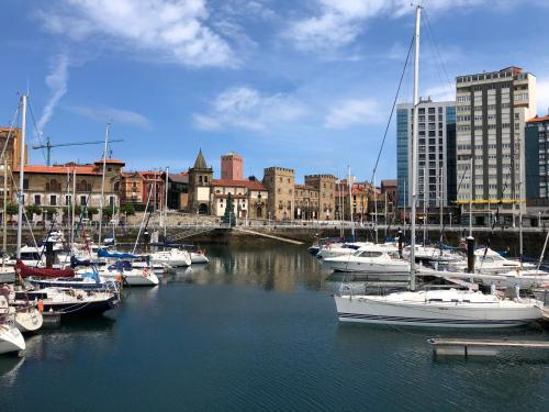 a bunch of boats are docked in a harbor at Alojamientos Muelle de Gijón in Gijón