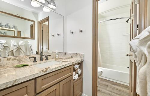 een badkamer met een wastafel, een toilet en een spiegel bij St Anton Condos #49 condo in Mammoth Lakes