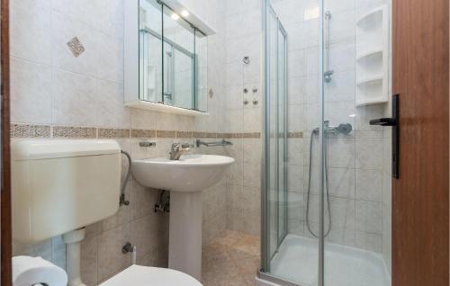 a bathroom with a toilet and a sink and a shower at 6 Bedroom Cozy Apartment In Nin in Nin