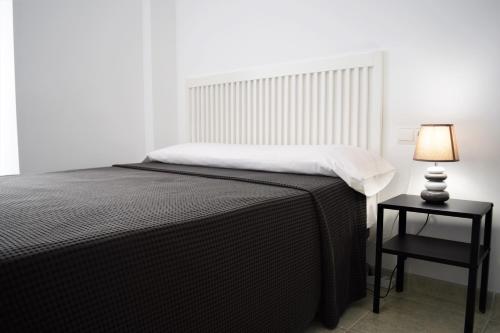 a bedroom with a bed and a table with a lamp at Hotel Mirablau in Aguadulce