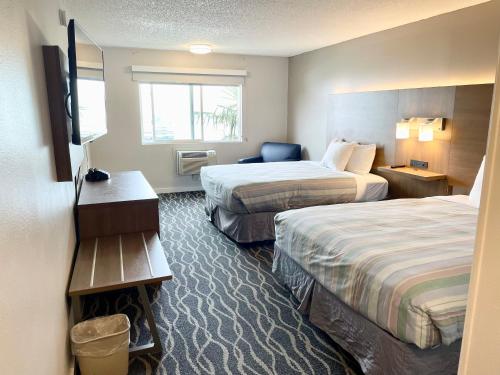 una camera d'albergo con due letti e una televisione di Dunes Motel Hillsboro a Hillsboro