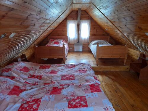 een slaapkamer met 2 bedden op een houten zolder bij Rooms Ma La in Karlovac