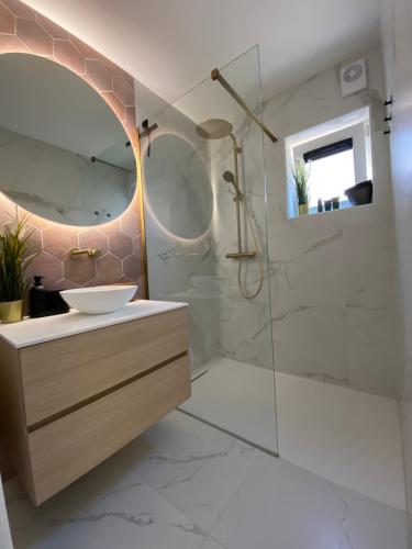 een badkamer met een wastafel en een spiegel bij Charlie & Chloé’s beachcondo ***** in De Haan