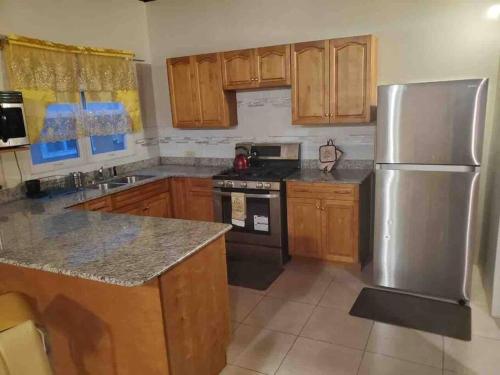 拉納韋貝的住宿－K&D EXCLUSIVE At the Vistas，厨房配有木制橱柜和不锈钢冰箱。