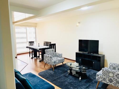 sala de estar con sofá, TV y mesa en Moderno y Cómodo Apartamento con la Mejor Ubicación en Sopocachi, en La Paz