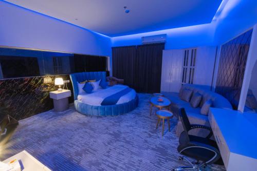 فندق ابيات الشمال في رفحاء: غرفة زرقاء مع سرير وأريكة