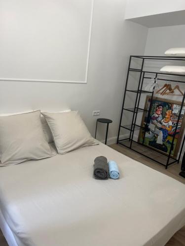 a white bed with two hats on top of it at Touchlux apartments in Cannes