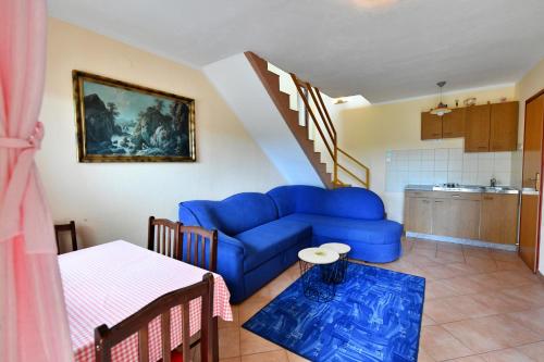 a living room with a blue couch and a kitchen at Guesthouse Ante Hodak in Seliste Dreznicko