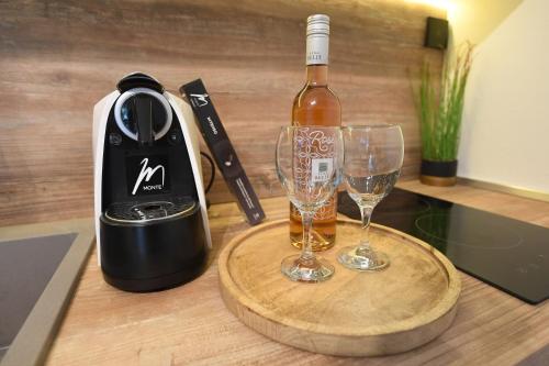 a bottle of wine and two wine glasses on a counter at Apartment by the sea Renata in Punta Skala in Petrcane