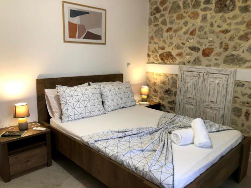 a bedroom with a bed and two night stands with lamps at Oikia Stone House in seaside Kalo Chorio in Agios Nikolaos