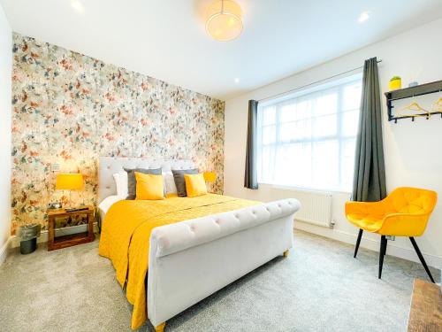 a bedroom with a bed with a yellow bedspread and a window at Ashfield Boutique Stays in Altrincham